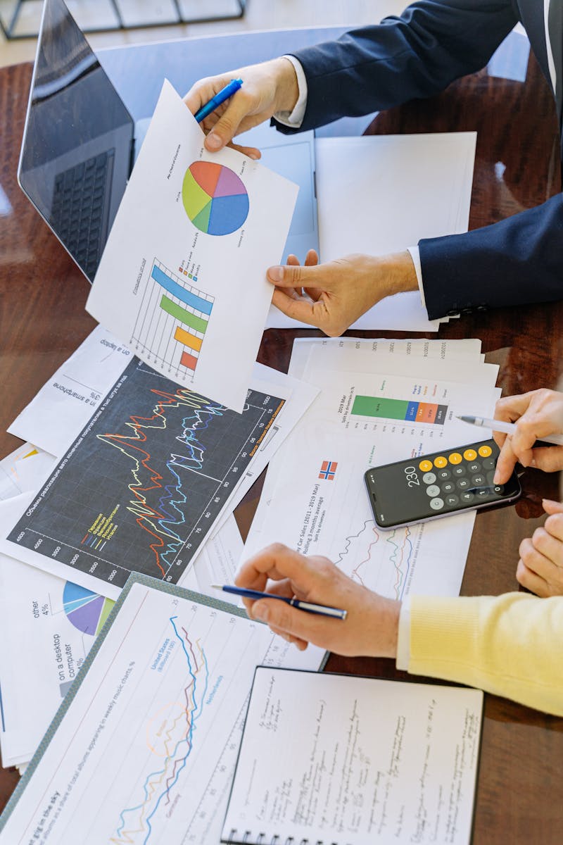 Photo by Antoni Shkraba Studio Business professionals analyzing financial charts and graphs during a meeting.
