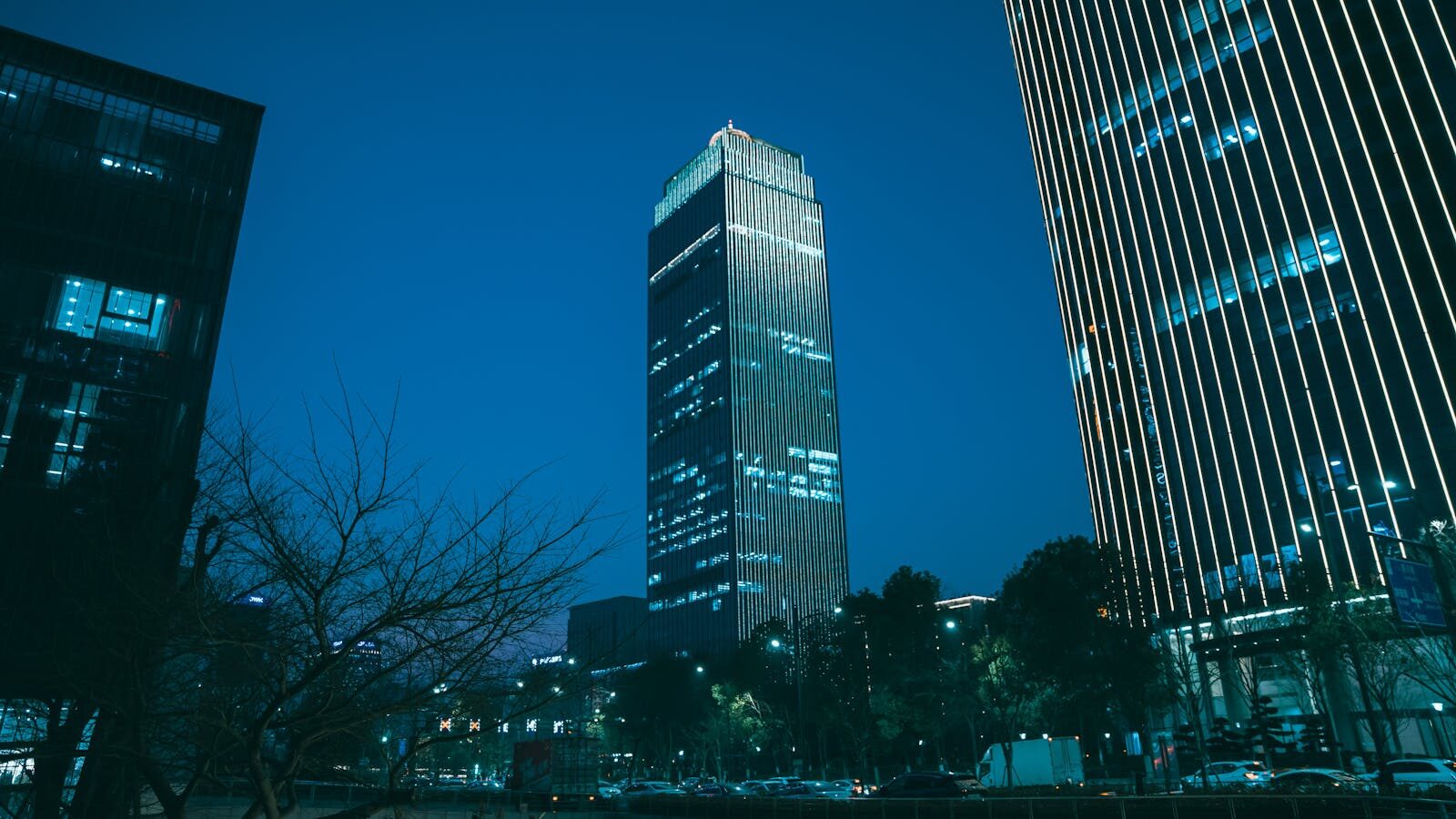 Photo by Acres of Film Majestic skyscrapers in Hangzhou, China, illuminate the twilight skyline with modern architectural designs.