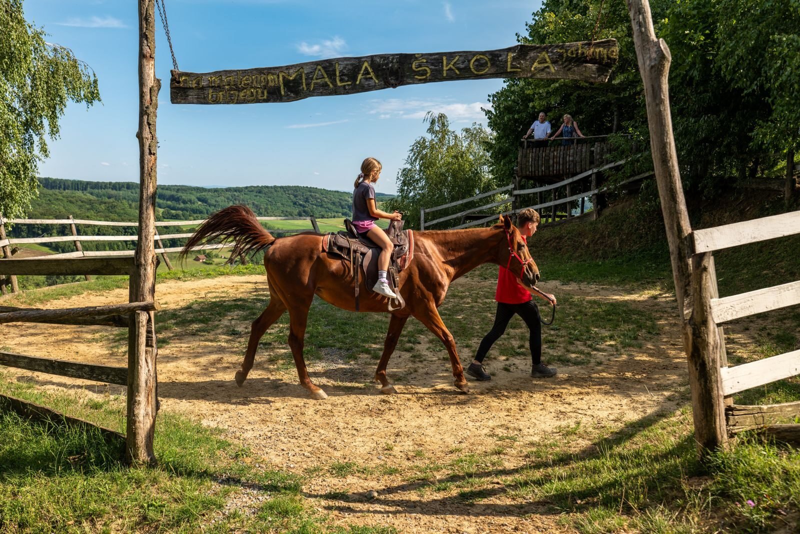 Photo by Vladimir Srajber A child rides a horse led by an instructor at Mala Skola in scenic Croatian countryside.